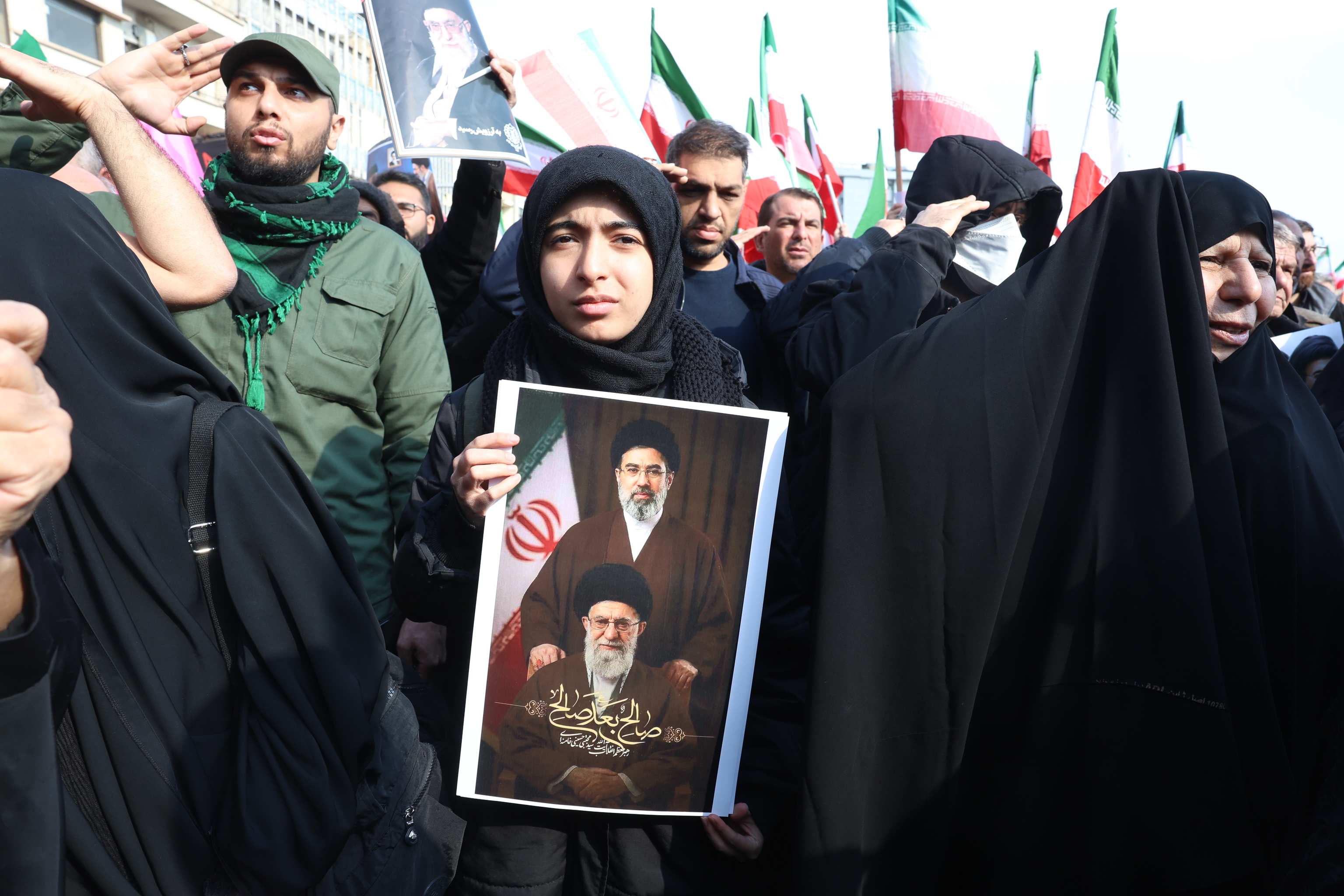 Una mujer iraní muestra una foto del fallecido ayatolá Ali Jamenei.